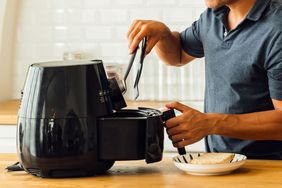 A person uses an air fryer