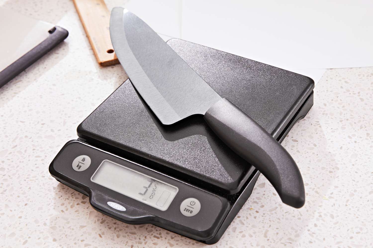 A knife being weighed on a kitchen scale