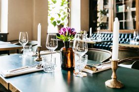 A restaurant table with wine glasses and candles