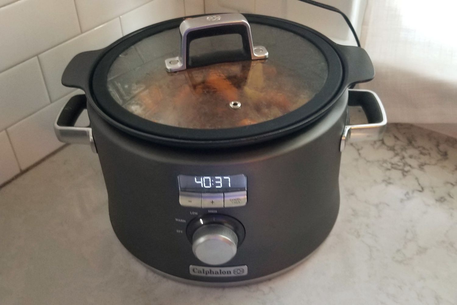 The Calphalon 5.3-Quart Digital Sauté Slow Cooker, Stainless Steel sitting on a kitchen counter