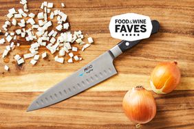 Mac Knife 8-Inch Hollow Edge Chef's Knife on a wooden cutting board with diced and whole onions