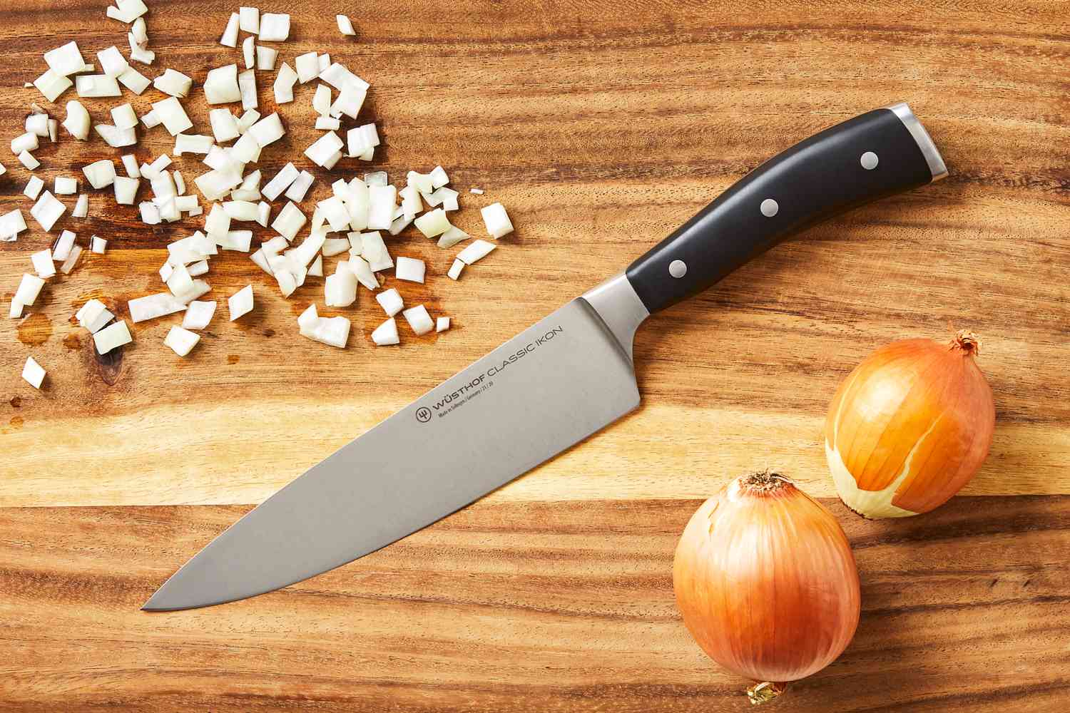 Wusthof 8-Inch Classic Chef's Knife on a wooden cutting board with onions.