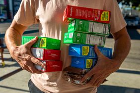 A person carries 10 boxes of Girls Scout cookies