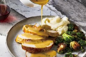 Turkey gravy being poured onto sliced turkey