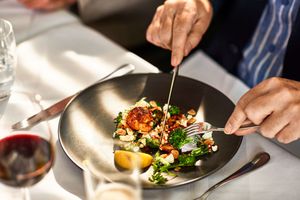 A person enjoys a dish at a restaurant