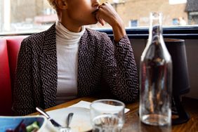 A person sitting alone in a restaurant booth