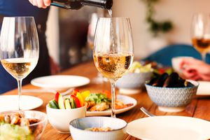 A person pours a glass of white wine