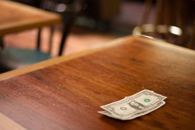 A small cash tip left on an empty restaurant table